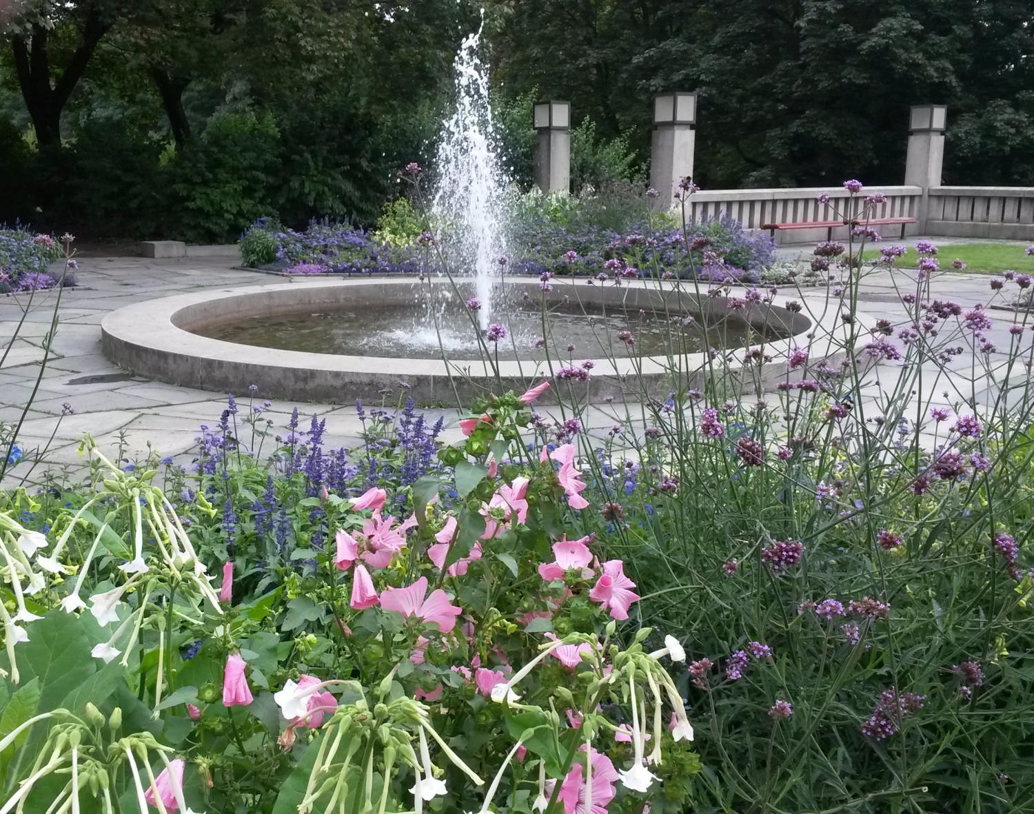 Runder Springbrunnen in einem schön blühenden Garten, Feng Shui Bischoff Schleswig Holstein